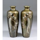 A pair of Japanese bronze vases of baluster form, each inlaid with coloured metals including gold,