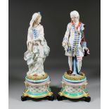 A pair of late 19th Century bisque porcelain figures of a gallant and his companion, both in 18th