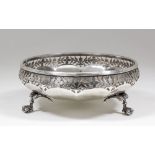 A George V silver circular bowl of panelled form and with sides pierced with floral and leaf