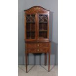 An Edwardian mahogany display cabinet inlaid with a basket of flowers, ribbon and bellflower swag