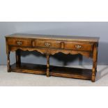 An oak dresser base in the manner of Titchmarsh and Goodwin, with moulded edge to top, fitted