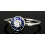 A modern silvery coloured metal mounted sapphire and diamond set target pattern ring, the central