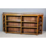 A late Victorian walnut dwarf open front bookcase with spindle turned gallery to back and angled