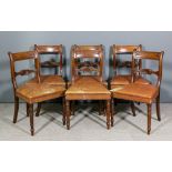 A set of six late George III mahogany dining chairs with panel backs, shaped crest rails, the