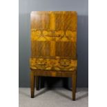 A 1930's walnut and figured walnut cocktail cabinet of Art Deco design, the upper part with mirrored