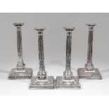 A set of four George III silver pillar candlesticks with stop fluted columns, the square bases