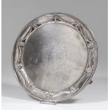 A late Victorian silver circular salver of Neo-classical design, the rim embossed with oval paterae,