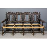 A Victorian oak framed four chair back settee, the backs boldly fretted and carved with eagle,