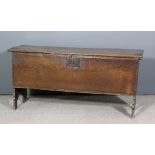 A 17th century oak plank coffer with moulded edge to lid and top rail, on shaped end supports, 52ins