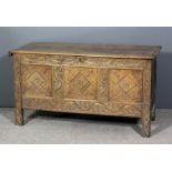 A 17th Century panelled oak coffer with plain lid, the three panelled front carved with lozenges,