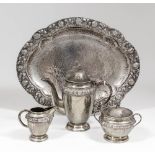 A 20th Century German silvery metal coffee service, the hammered circular bodies embossed with