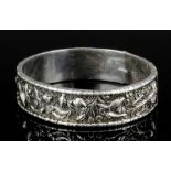 A Chinese silvery metal hinged stiff pattern bangle, the central panel cast with fish, sea shells