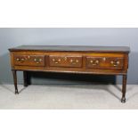 An 18th Century oak dresser base with one piece top, fitted three frieze drawers, on turned front