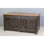 A late 17th/ early 18th Century panelled oak coffer with plain lid, the four panel front carved with