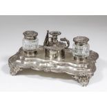 A William IV silver rectangular inkstand of shaped and moulded outline, the rim cast with flowers,