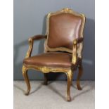 A French oak framed and parcel gilt open arm fauteuil of Louis XV design with shaped and moulded