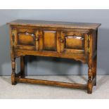 A panelled oak low sideboard in the manner of Titchmarsh & Goodwin, enclosed by a pair of shaped and