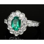 A modern 18ct white gold emerald and diamond ring, the oval cut emerald approximately 1ct surrounded