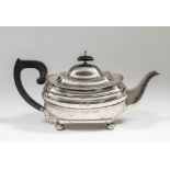 A George V silver rectangular teapot with gadroon mounts, ebonised finial and handle, on four ball
