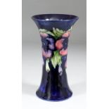 A Moorcroft pottery vase of waisted form tube lined and decorated in colours with "Pansy" design, on