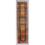 A Karajar runner woven in colours thirteen angular cross motifs, on a fawn ground within two