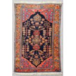 An antique Backtiari rug woven in colours with a bold central pole medallion and stylised branch and