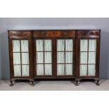 A 1920s figured mahogany dwarf bookcase of Georgian design, the recessed front with carved gadroon