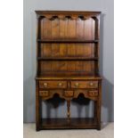 A small Titchmarsh & Goodwin oak dresser, the upper part with moulded cornice and shaped frieze,