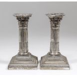 A pair of Edward VII silver pillar candlesticks with cast Corinthian capitols and stop fluted