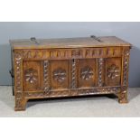 A 17th Century panelled oak coffer, the plain lid with oxidised strap hinges and the four panelled