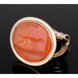 A late Victorian gold coloured metal mounted carnelian set seal, the face cut with a standing