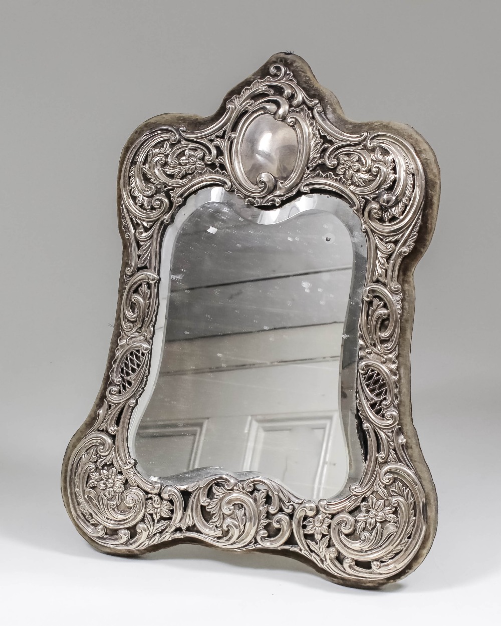 A late Victorian silver framed rectangular dressing table mirror of shaped outline, the silver