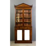 A William IV mahogany bookcase of architectural design the upper part with angled cornice with