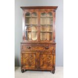 An early Victorian figured mahogany Secretaire bookcase, the upper part with moulded cornice,