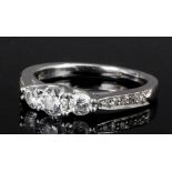 A modern 18ct white gold and platinum mounted three stone diamond ring, the shoulders set with