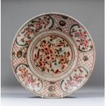 A Chinese "Swatow" porcelain charger enamelled in iron red and green with scattered flowers and
