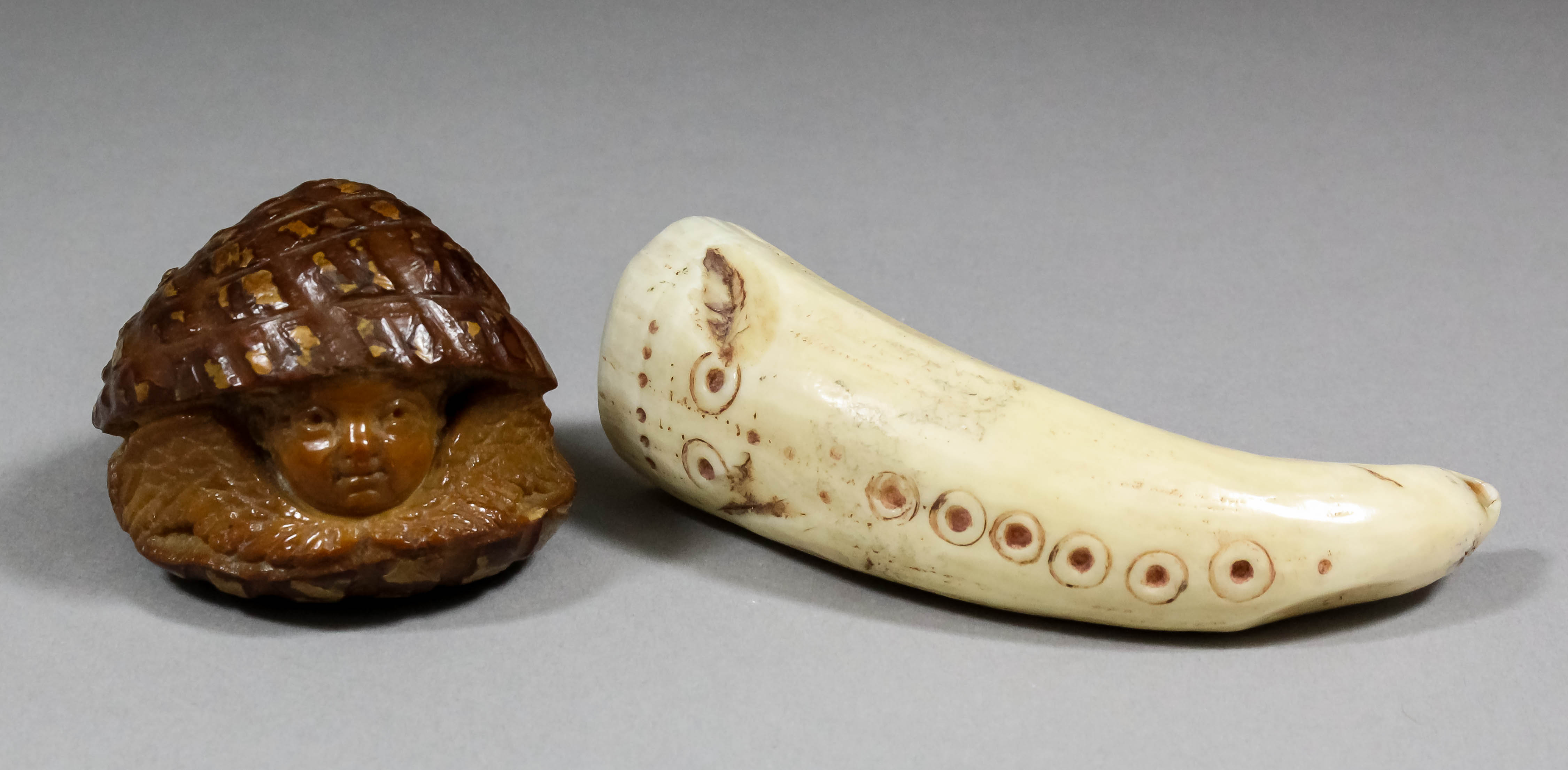 A small carved tusk with drilled circular designs to one front and hole to end, 3.5ins overall,