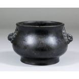 A Chinese dark patinated bronze circular two-handled censer of squat baluster form with cast
