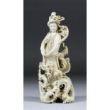 A Japanese carved ivory okimono of a female figure with basket, standing amongst turbulent waves and