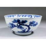 A Chinese blue and white porcelain bowl, the exterior painted with prunus, bamboo and fir trees, the