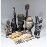 An interesting collection of West African carved wooden objects, including - Handled mortar carved