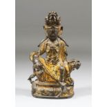 A Chinese lacquer gilt bronze figure of Guanyin seated on a qilin on a lotus base and holding a