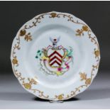 A Chinese armorial "Famille Rose" porcelain circular plate of shaped outline, the centre enamelled