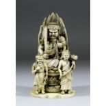 A Japanese carved ivory okimono of a male deity seated in the lotus position and holding a sword and