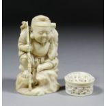 A Japanese carved ivory figure of a seated fisherman holding a carp and rod, 3.75ins (95mm) high (