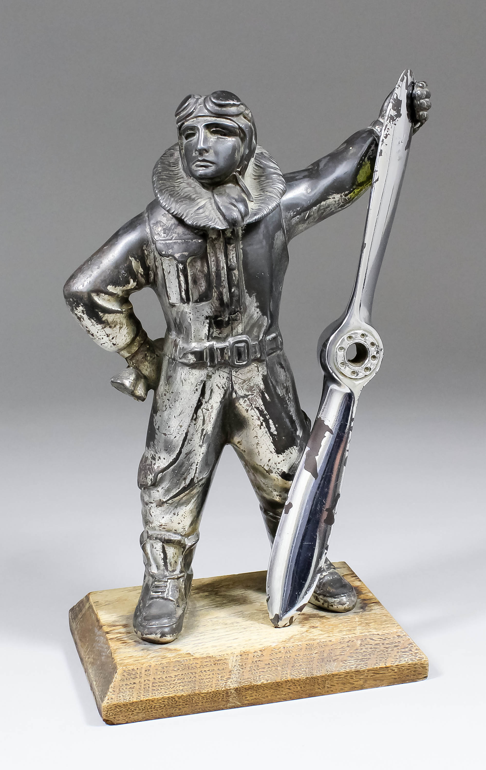 An early 20th Century desk lighter modelled as a nickel plated spelter figure of a standing Airman