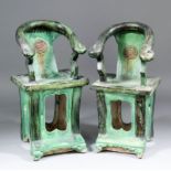 A pair of Chinese Sancai glazed pottery horse-shoe backed chairs with pierced bases, on moulded