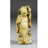 A Japanese carved ivory standing figure of a man, his arms upraised holding a rope with a toad at