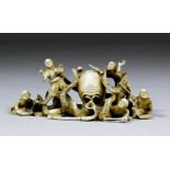 A Japanese carved ivory okimono of five men with sticks being attacked by an octopus, 5ins (127mm)