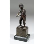 Late 19th/early 20th Century Eastern European School - Bronze figure of a standing urchin holding